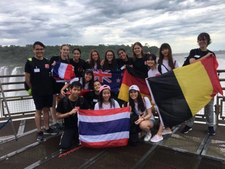 The exchange students on the trip with flags from their host countries, standing in front of La Garganta del Diablo.
