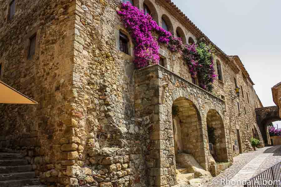 Brightly coloured bougainvillea on medieval buildings in Pals Spain
