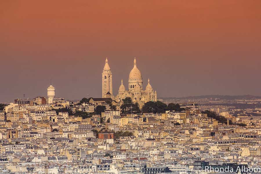 Avoid crowds in Paris by visit sites early in the morning, like Sacre Coeur in the distance in Paris France