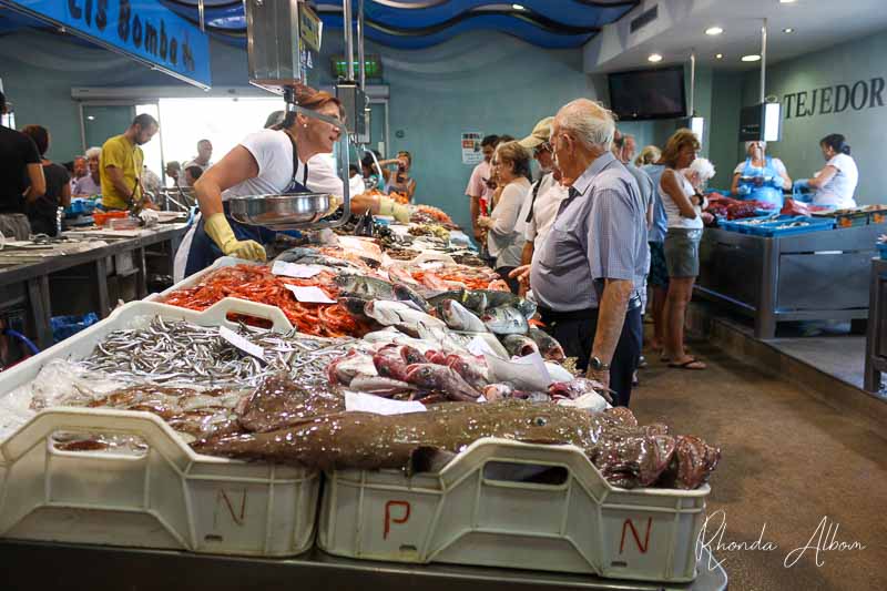 Discussing price by using Spanish phrases for travel at the fish market attached to the fish auction in Palamos, Spain