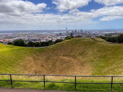 At the Mount Eden volcano summit overlooking the crater and the skyline of Auckland city