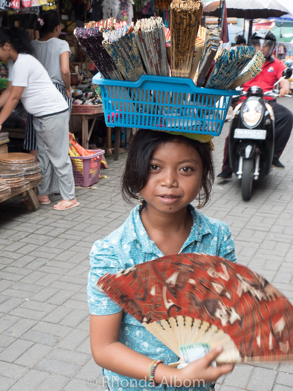Bali Itinerary: Cruise Port Adventure in Ubud Indonesia 8 Girl selling fans in a market in Ubud, Bali