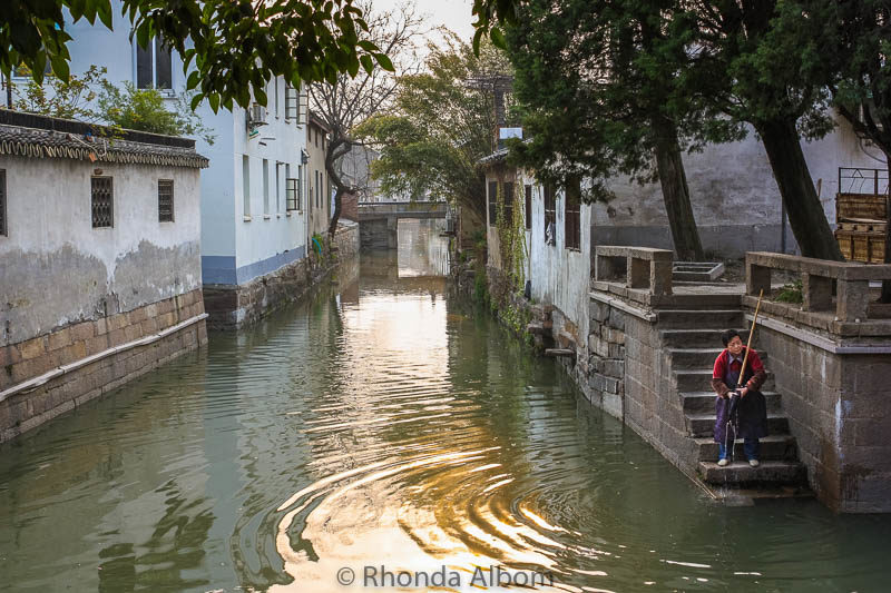 Exploring Gardens and Observing Everyday Life in Suzhou China 2 Woman washing her mop in a canal in the Pingjiang Historic Quarter of Suzhou China