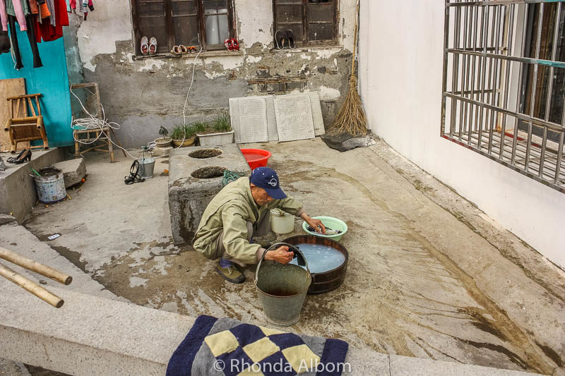 Exploring Gardens and Observing Everyday Life in Suzhou China 6 A man washing laundry at well in Suzhou China