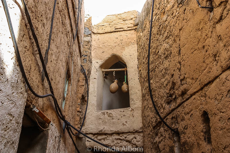 Oil and water jars hang in a window in Misfat Oman