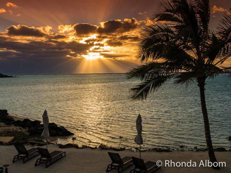 Rarotonga Travel Guide: What You Need to Know Before You Visit 3 Deep orange sunrise over the ocean and seen from a Rarotonga beach resort
