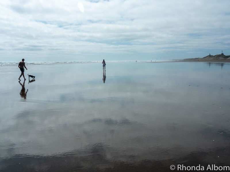 Walking along Muriwai beach at low tide, the reflection looks like walking on glass