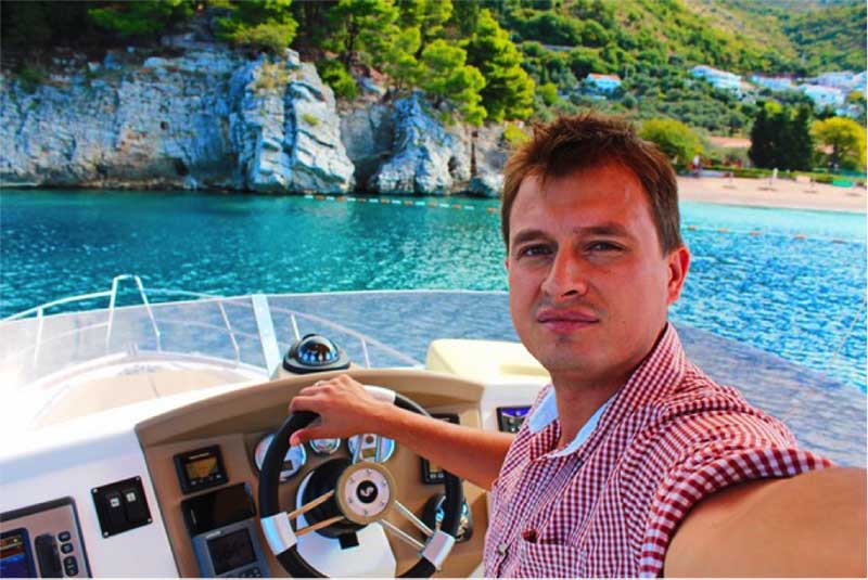 Private Guide at the helm of a boat with white cliffs ahead, this is just one of many types of tours out there.