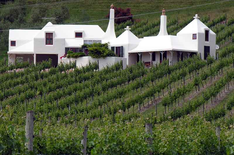 Things to Do in Hawkes Bay NZ: Wine Trails, Culture, Art Deco, and More 10 Rows of green grape vines contrast the stark white building of Te Mata Vineyard in New Zealand