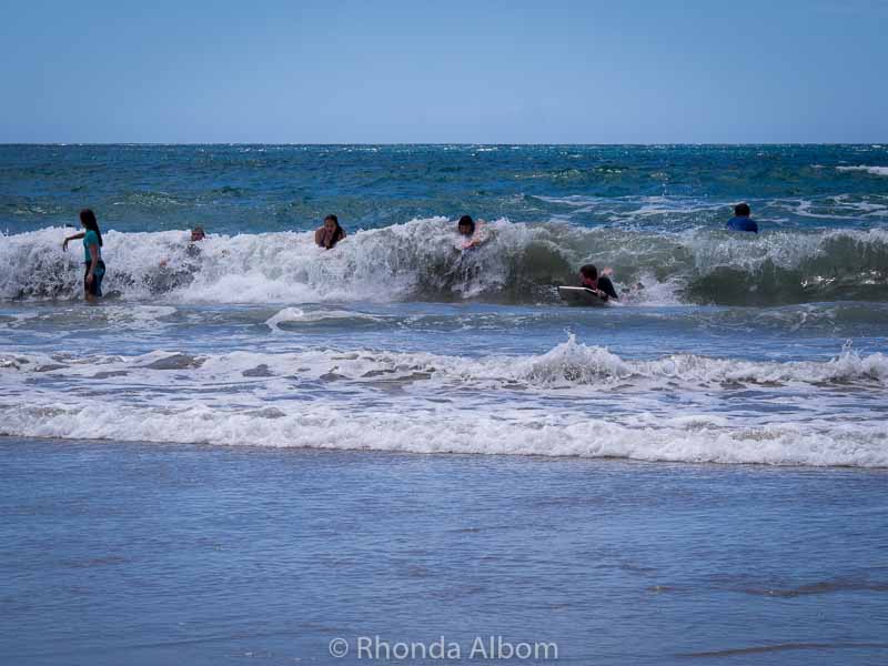 Waipu Caves, Glow Worms and Other Things to Do in Waipu New Zealand 11 Splashing and swimming in the surf at a beach in New Zealand