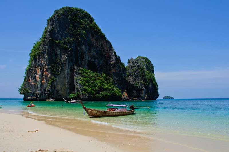 Kayak at the shore in front of a huge rock outcropping on Phra Nang one of the best beaches in Thailand