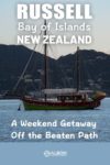 A ketch at anchor seen from the shores of Russell Bay of Islands New Zealand