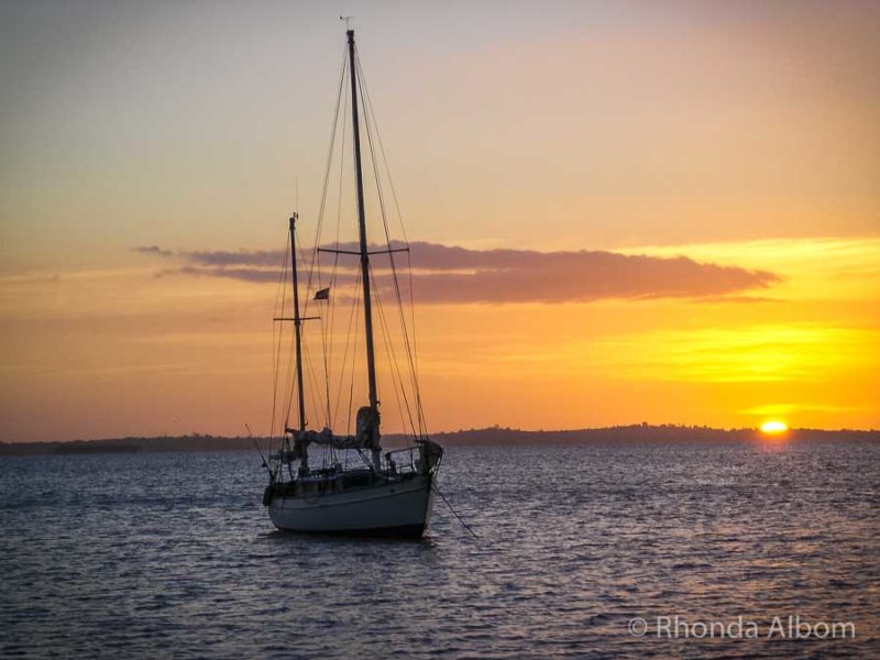 yacht at anchor with sunset in the background
