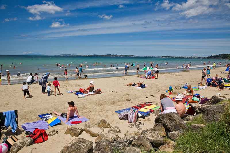 Orewa Beach: See Why This Local's Paradise is an Auckland Getaway 4 People enjoying a summer day on Orewa Beach