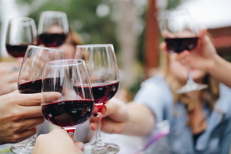 9 Best Waiheke Wineries for a Fun Day Out 3 four wine glasses in hand making a toast