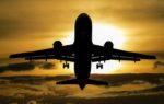 Airplane silhouette at sunset representing flight delay compensation