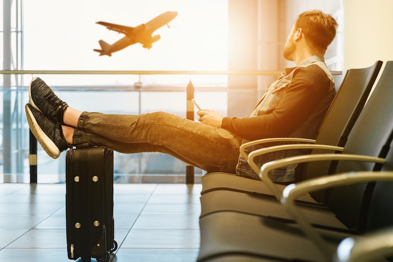 Man wondering if he can get flight delay compensation as he waits for his flight while watching another take off