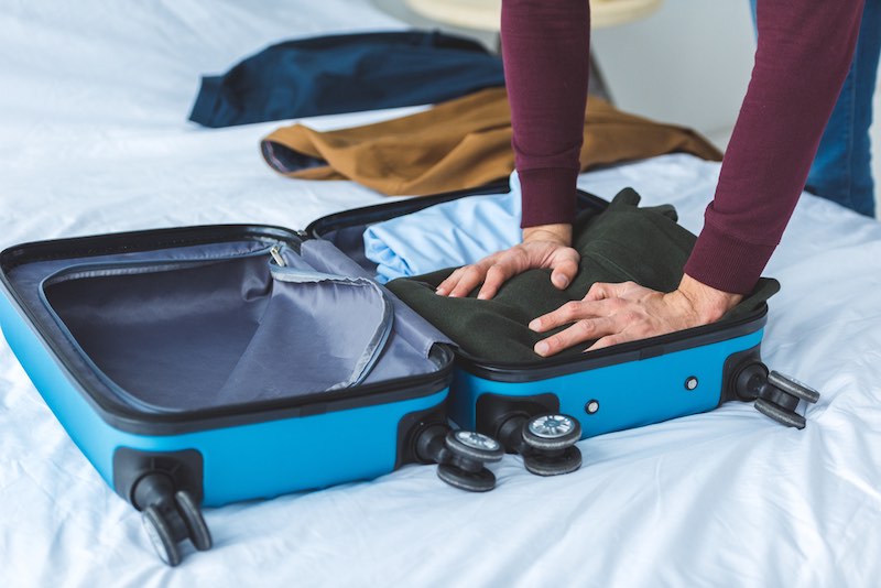 Arms of someone who is packing a carry on bag