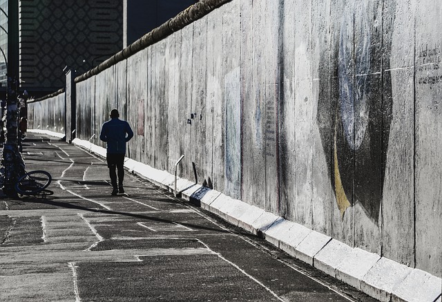 Man jogging alongside the Berlin Wall before it came down.