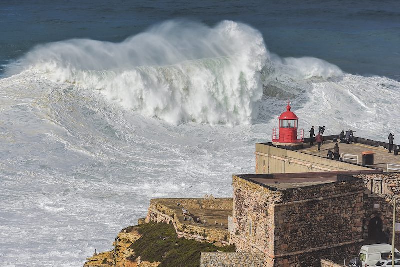 Praia do Norte lighthouse and huge waves in Nazare Portugal