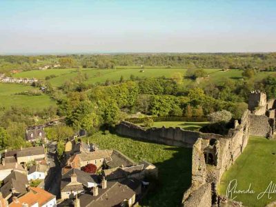 Rolling hills and castle ruins in the British countryside seen during our England road trip.