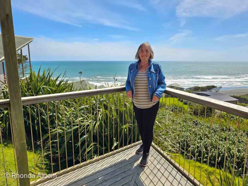 Rhonda Albom on the deck of a chalet at Castaways Resort, Karioitahi Beach, near Waiuku in NZ.