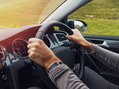 Person driving on the left hand side of the road, the steering wheel on the right.