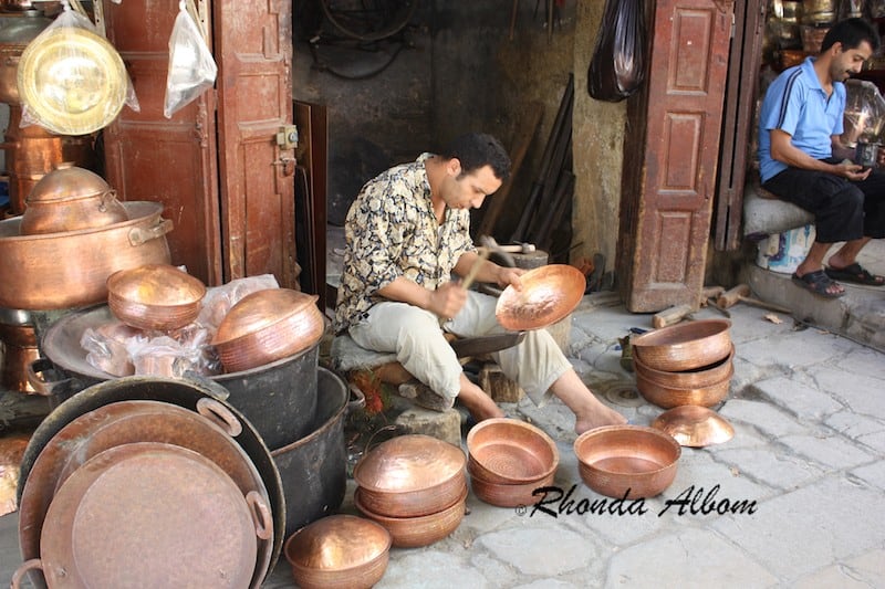 Coppersmiths Hammer Pots and Other Wares in Seffarine Square in the Old Medina of Fez, Morocco Coppersmiths Hammer Pots and Other Wares in Seffarine Square in the Old Medina of Fez, Morocco