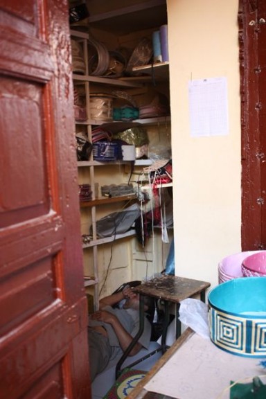 Meknes Morocco, craft booth where the man who runs is asleeps in the booth on the floor Meknes Morocco, craft booth where the man who runs is asleeps in the booth on the floor